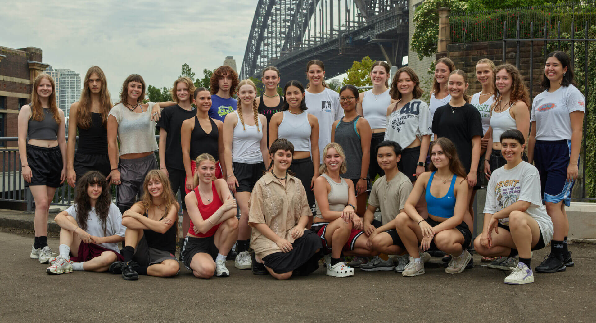 Sydney Dance Company's Pre-Professional Year 2 cohort standing in a group with the Sydney Harbour Bridge in the background.