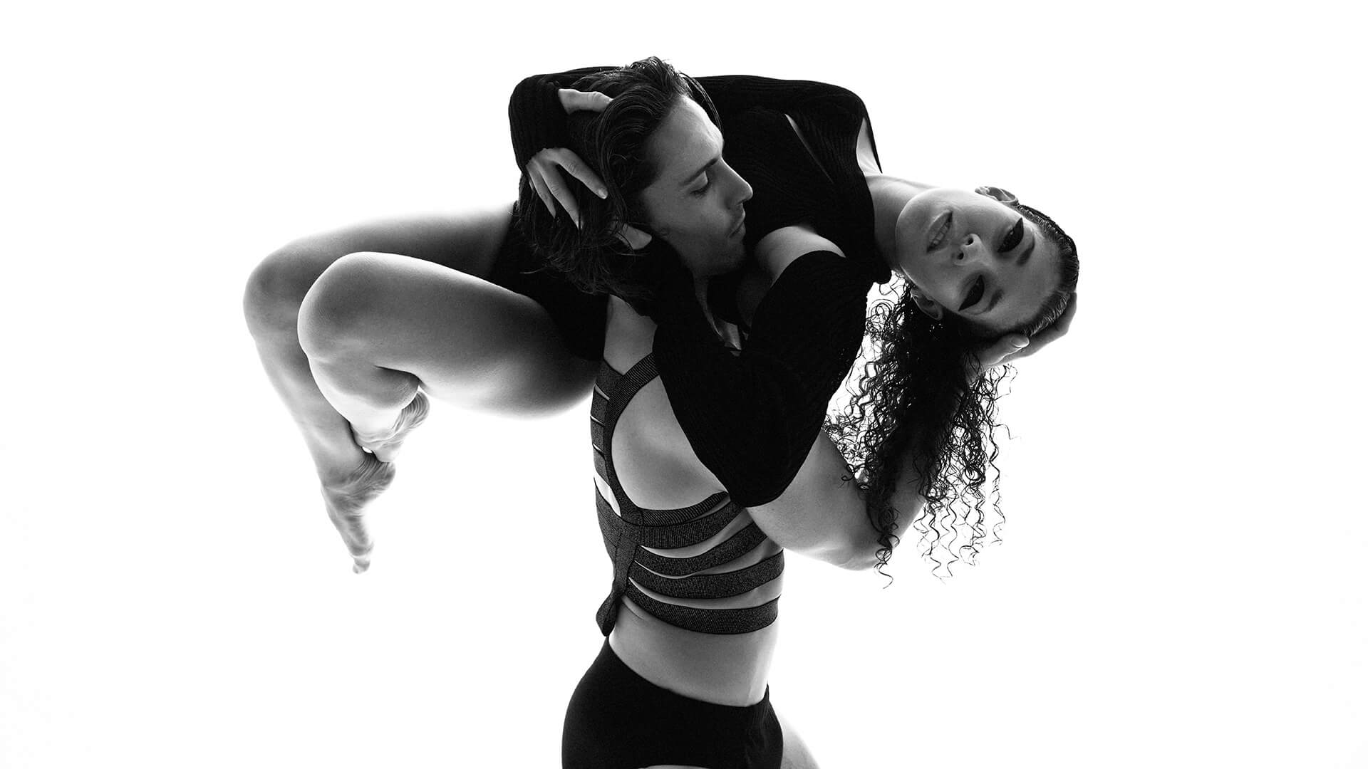 Black and white photo of a male dancer holding up a female dancer